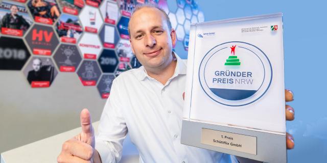 Christian Hülsewig von Schüttflix hält den Gründerpreis NRW in seiner Hand