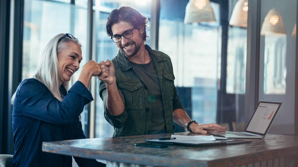 A younger man and an older woman fistbumping