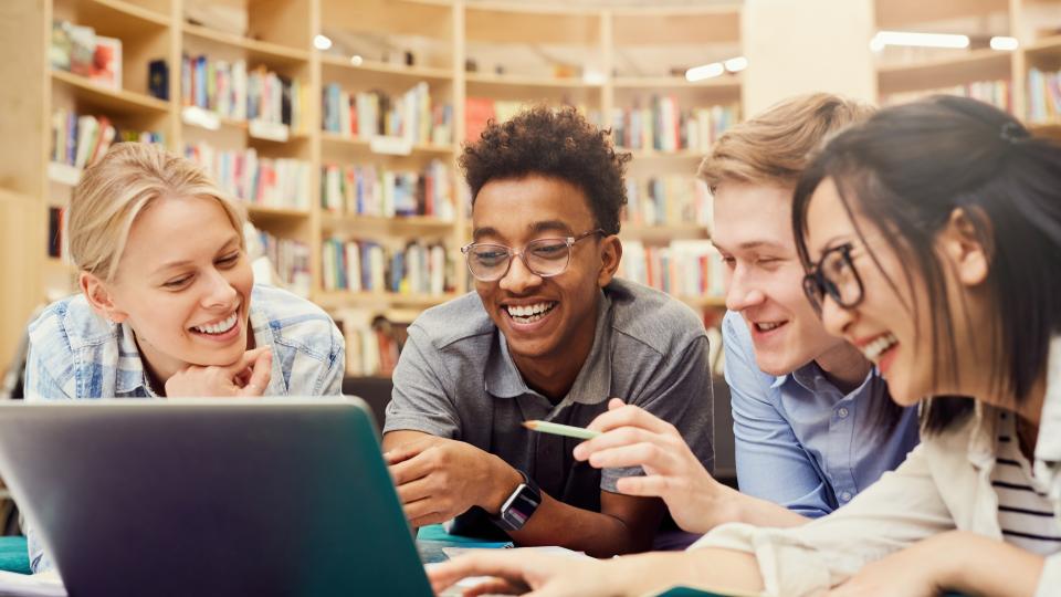 Four students sitting around a laptop