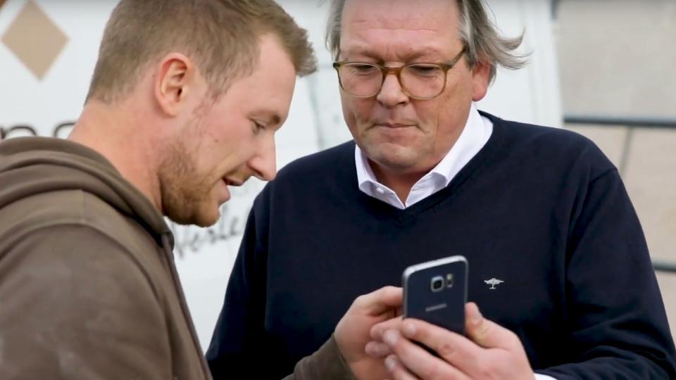 Mario Weidemann und Peter Hagedorn und schauen auf ein Smartphone.