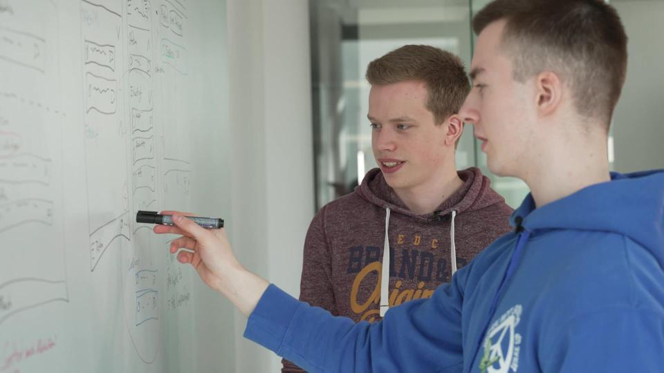 Nils Reichardt and Jonas Sander, two young men, standing at a whiteboard with a sketch.