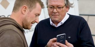 Mario Weidemann and Peter Hagedorn looking at a smartphone.