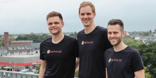 The three founders of DynAmaze standing next to each other on a balcony