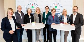 The jury members of the GRÜNDERPREIS stand at bar tables