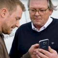 Mario Weidemann and Peter Hagedorn looking at a smartphone.