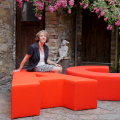 Birgitta Lancé sitting on one of her pieces of outdoor furniture.