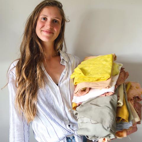 Founder Nora Mühlmann holds pieces of clothes in her hand