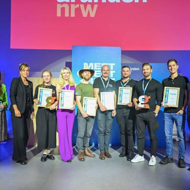 Gruppenbild der Gewinner des Finale der Roadshow "Meet, Greet + Beat" mit Ministerin Neubaur